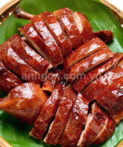 Vịt quay da giòn nguyên con với lớp da vàng óng giòn rụm, thịt mềm ngọt, ăn kèm rau răm, dưa leo và nước chấm đặc biệt